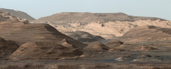 An image taken by the Curiosity Rover MastCam instrument shows layered sedimentary rocks composing Mount Sharp. The rover has been driving from the floor of Gale crater up through the rocks within these hills in order to understand how the rocks